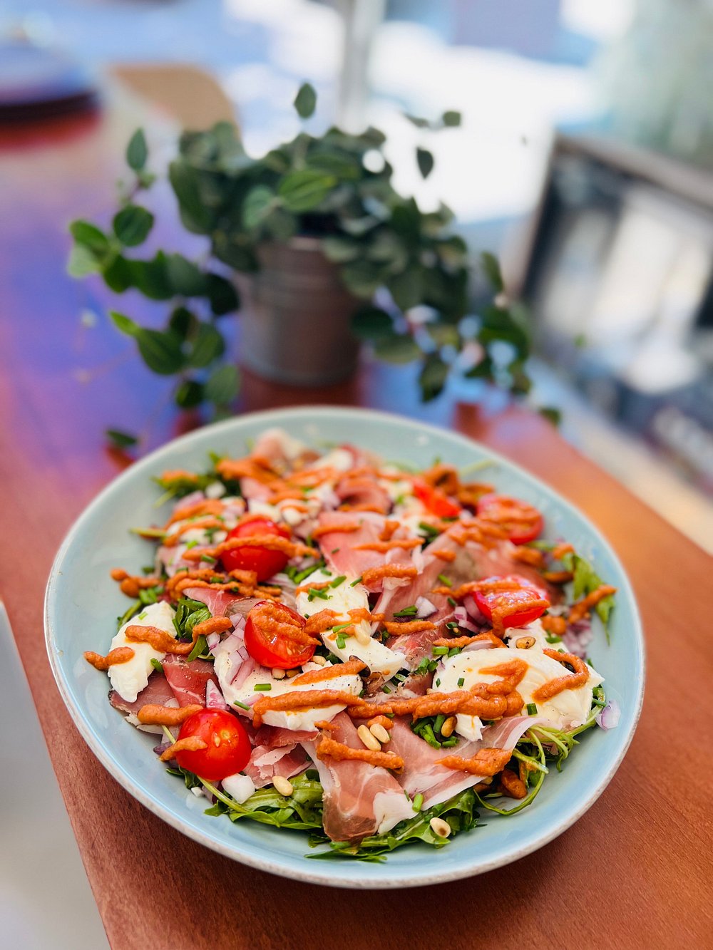 Salade de roquette, jambon cru, croûtons croustillants, tomates et mozzarella.